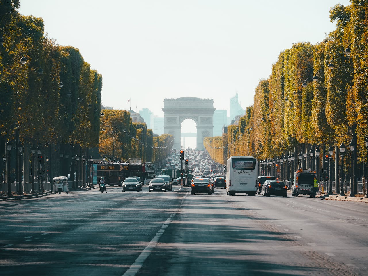 Nos Offres View of the Arc de Triomphe down a busy Champs Élysées in Paris, France, during fall.